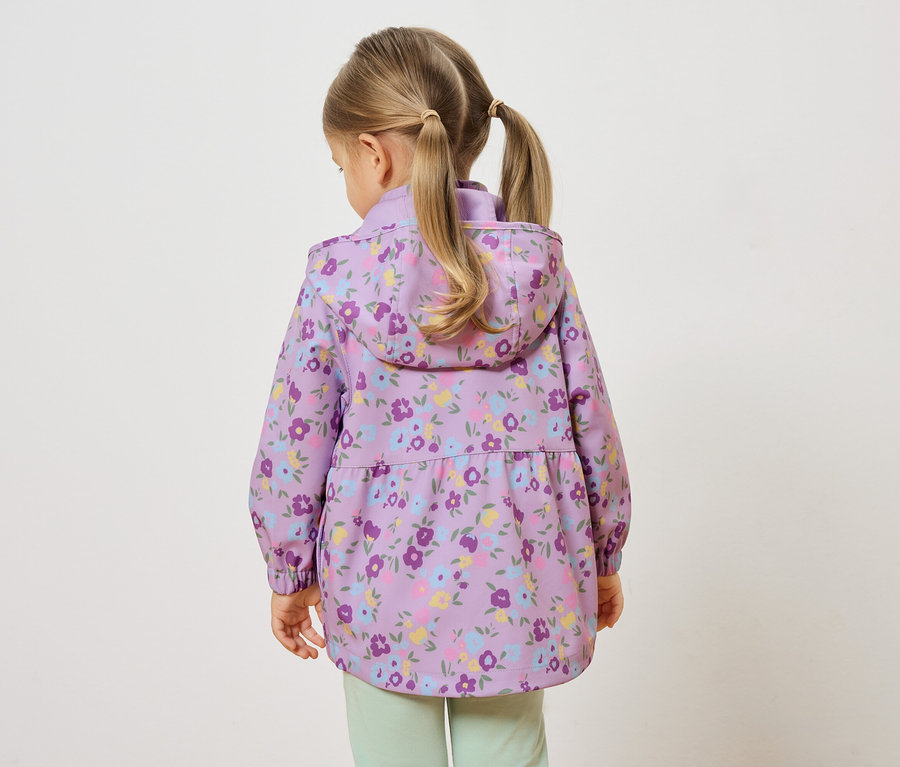 Vue arrière d'une petite fille avec des tresses blondes portant une veste violette à fleurs et un pantalon vert clair.