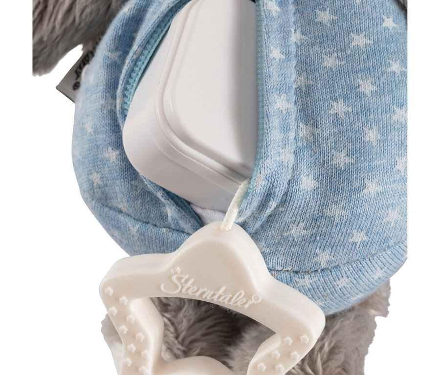 Gros plan d'un jouet musical avec un mécanisme de boîte à musique blanc, recouvert de tissu bleu à motifs d'étoiles. Une poignée de traction blanche en forme d'étoile avec « Sterntaler » est attachée, avec de la fourrure grise visible en dessous.