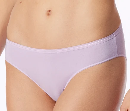 Une personne portant une culotte lilas clair avec une fine bande, le ventre et le haut des cuisses sont visibles.
