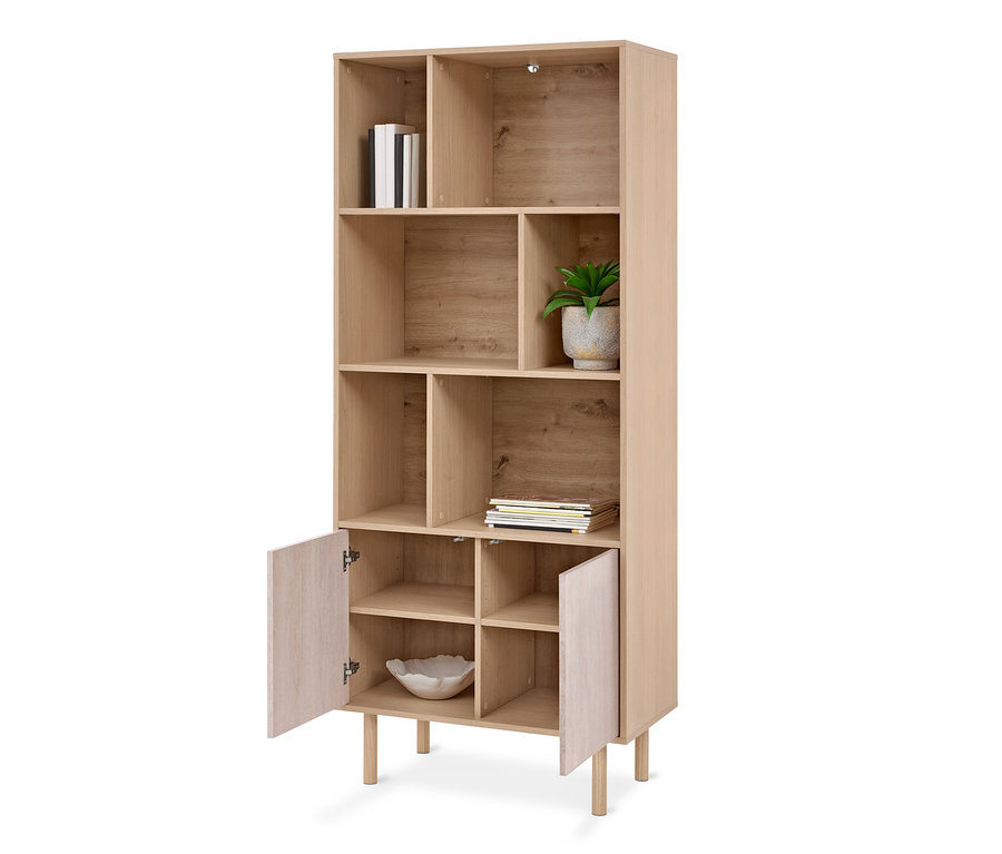 Étagère en bois clair avec des compartiments ouverts et deux petites portes ouvertes en bas, contenant des livres, une plante en pot et un bol décoratif.