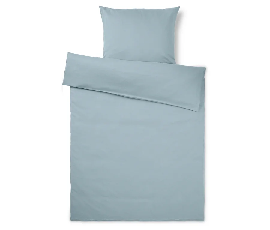 Parure de lit bleu clair, comprenant une taie d'oreiller et une housse de couette, posée à plat sur un fond blanc.