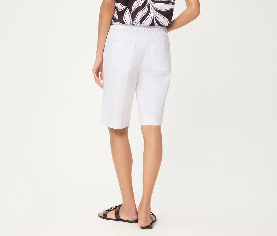 Personne de dos portant un short Olsen blanc, un haut à motifs et des sandales noires.