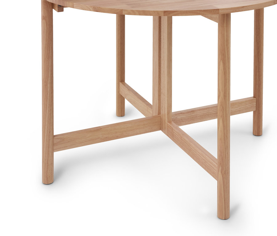 Table en bois clair avec plateau rond et traverses de support sur fond blanc.