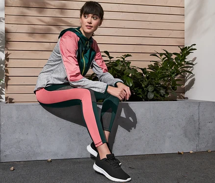 Une femme est assise sur un banc en béton et porte un legging thermique, extra chaud.