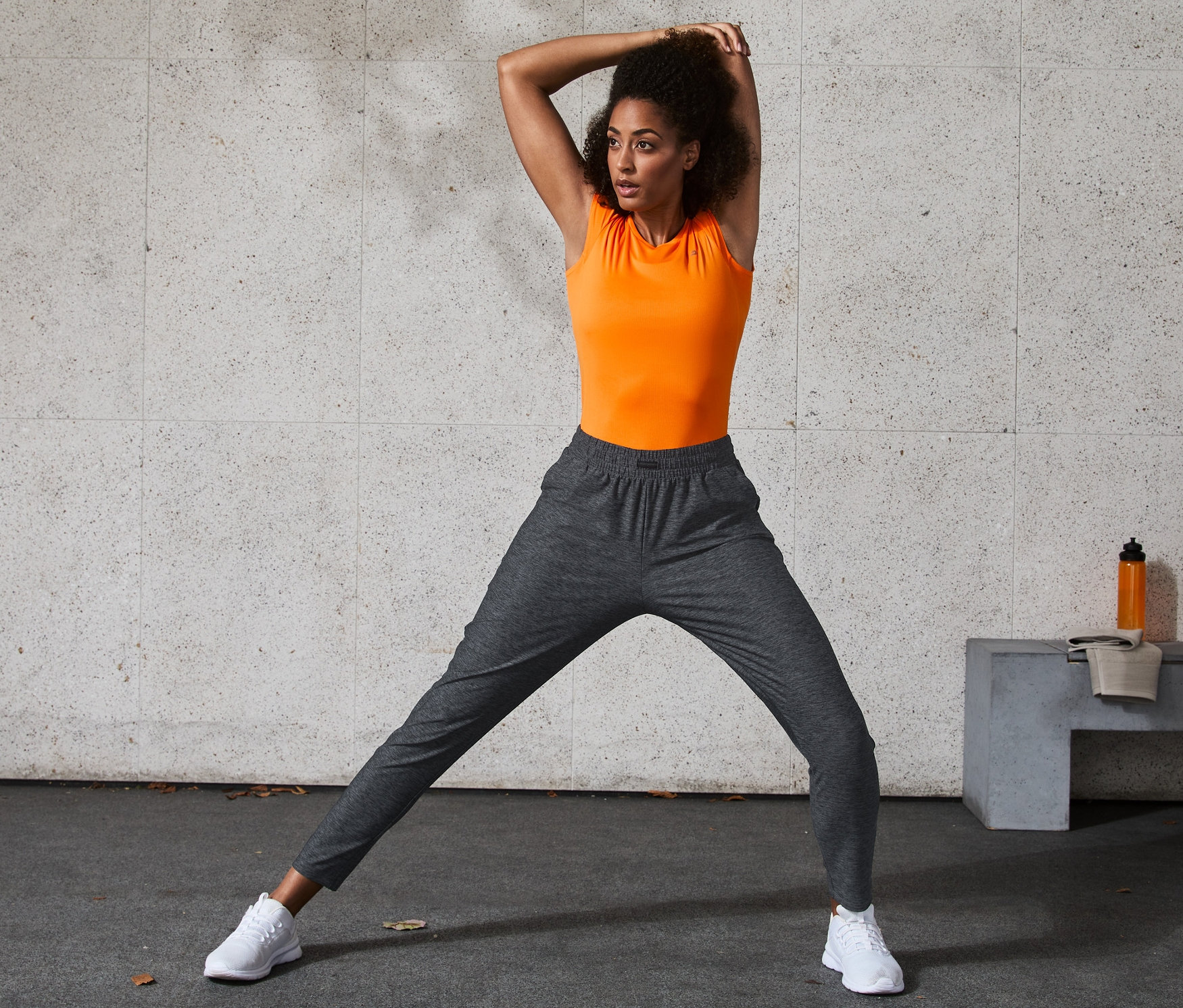 Femme étire ses jambes en pantalon de sport.