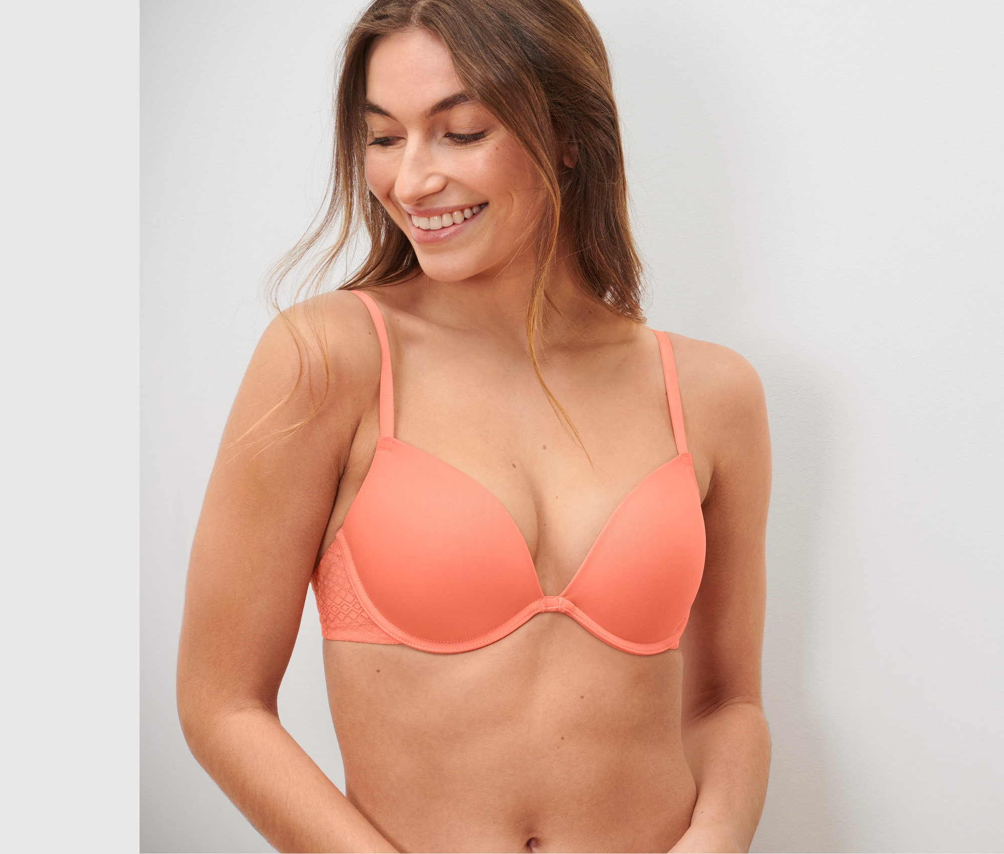 Femme souriante portant un soutien-gorge push-up avec de la dentelle.