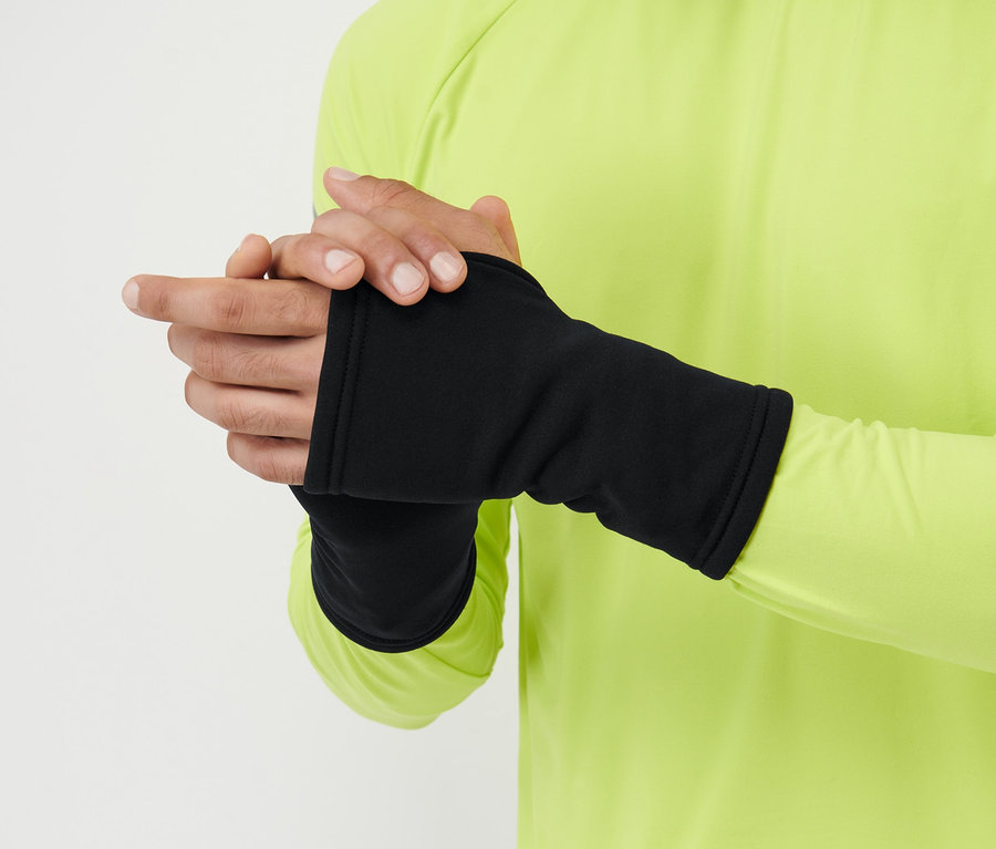 Un homme porte des mitaines noires et un t-shirt jaune à manches longues.