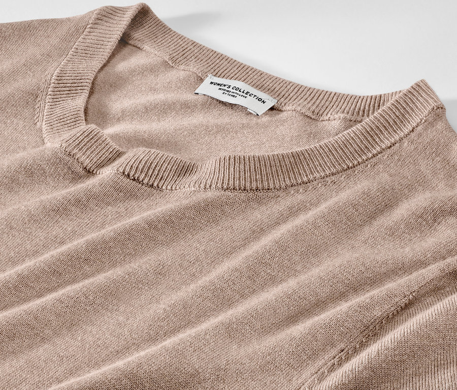 Détail d'une robe en maille fine marron clair.