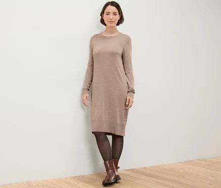 Femme posant dans une robe marron en maille fine.