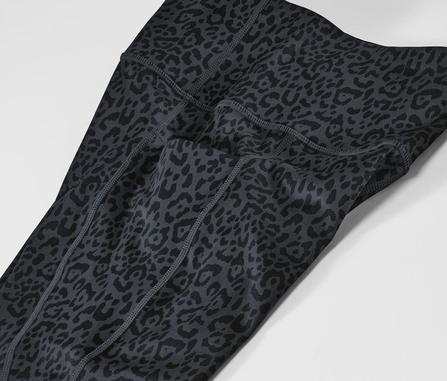 Gros plan sur un legging de sport gris et noir à motif animalier.