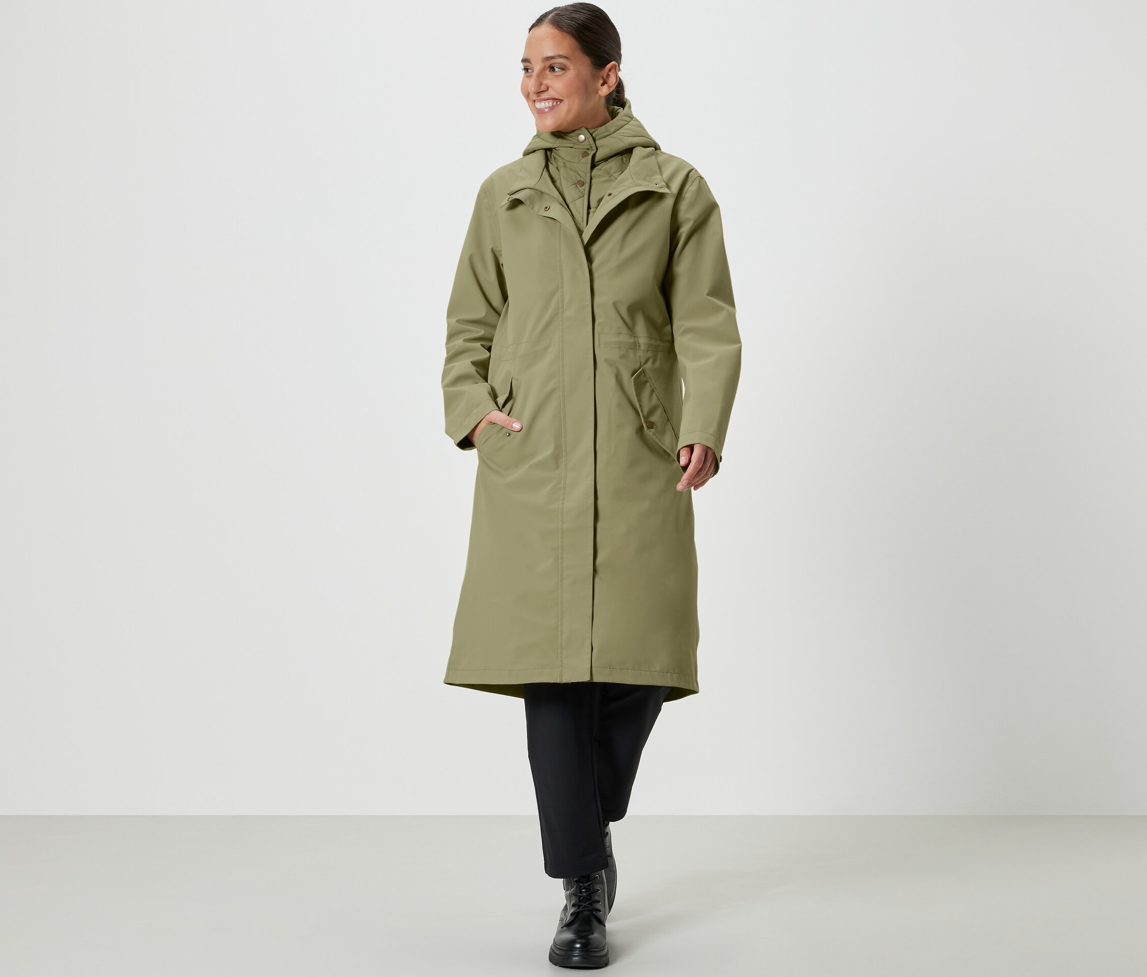 Femme marchant et portant un manteau de pluie kaki.