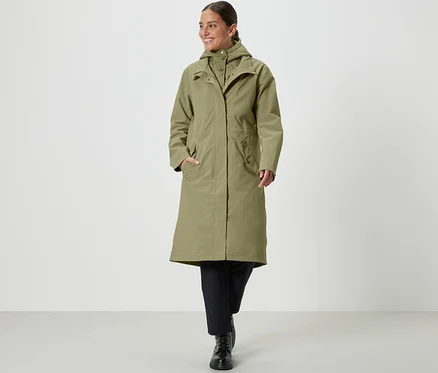 Femme marchant et portant un manteau de pluie kaki.