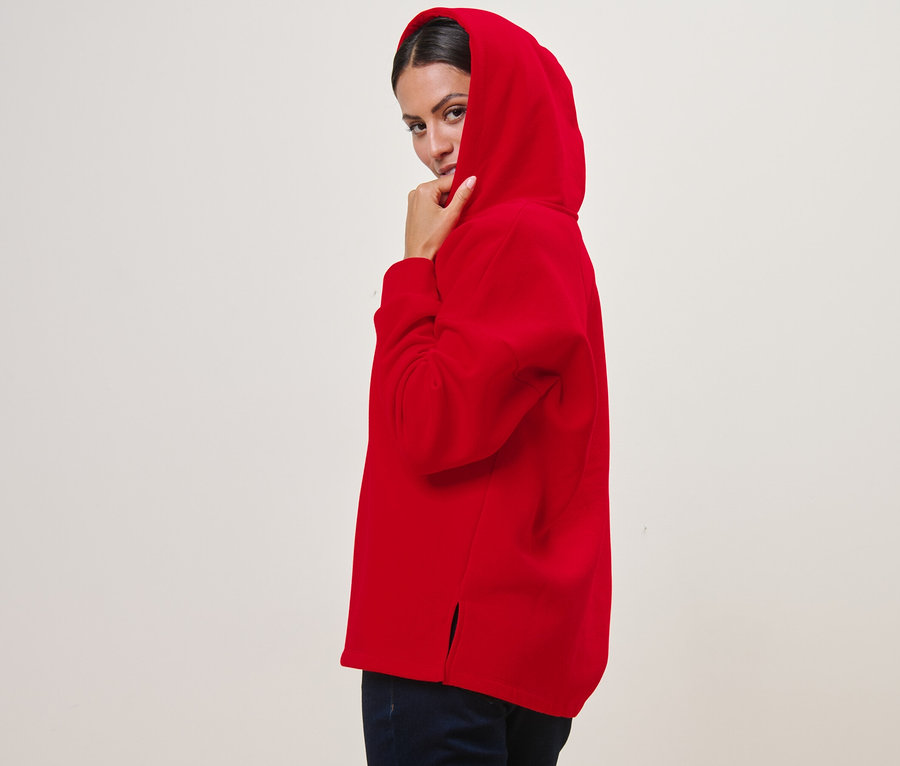 Femme posant dans un sweat à capuche rouge.