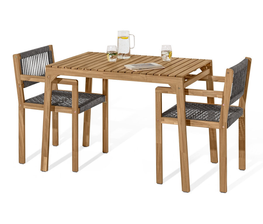 Deux chaises et une table de l'ensemble balcon avec textile tissé. Des verres d'eau et une carafe sont posés sur la table.