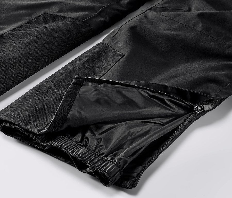 Gros plan sur un pantalon de ski high-tech noir avec fermeture éclair sur la jambe.