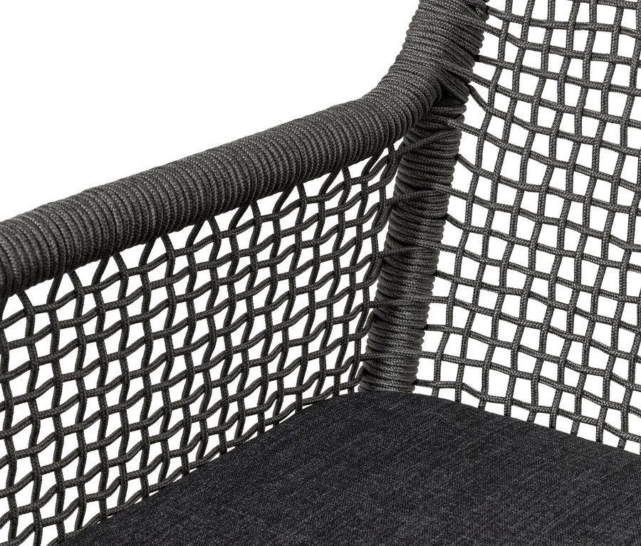 Gros plan d'une chaise à dossier haut en textile tressé.