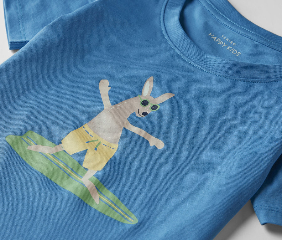 Pyjama court bleu pour enfant avec un kangourou faisant du surf sur une planche.