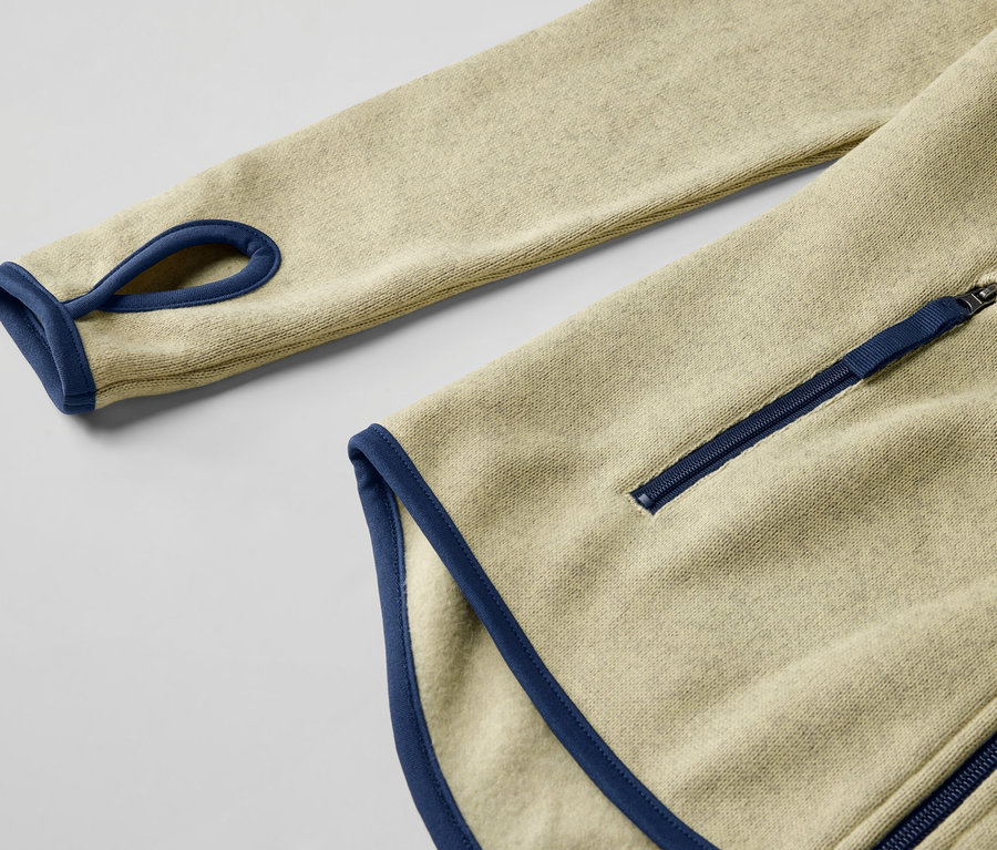 Gros plan sur une veste en polaire tricotée jaune avec des détails bleus et une fermeture éclair.