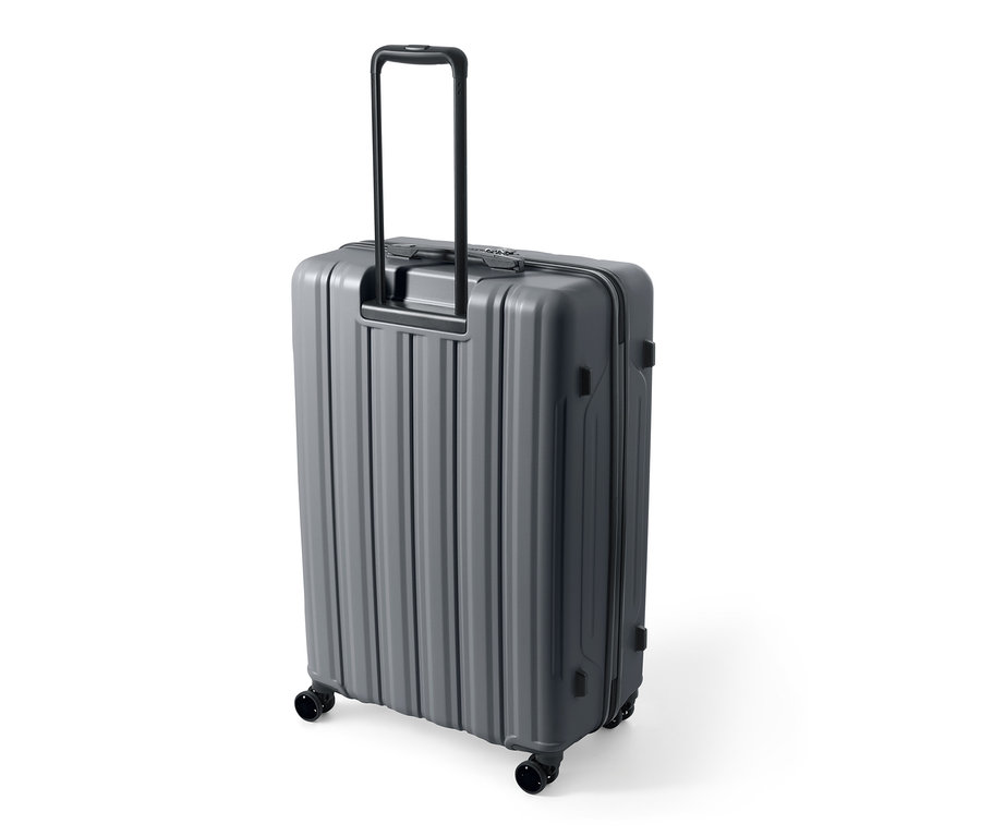 Valise rigide grise de grande taille en matériau recyclé avec poignée déployée.