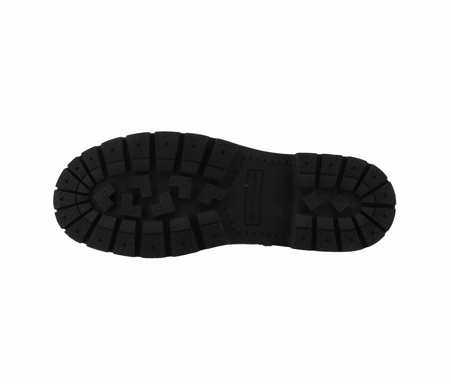 Gros plan sur la semelle noire d'une chaussure avec un motif distinct.