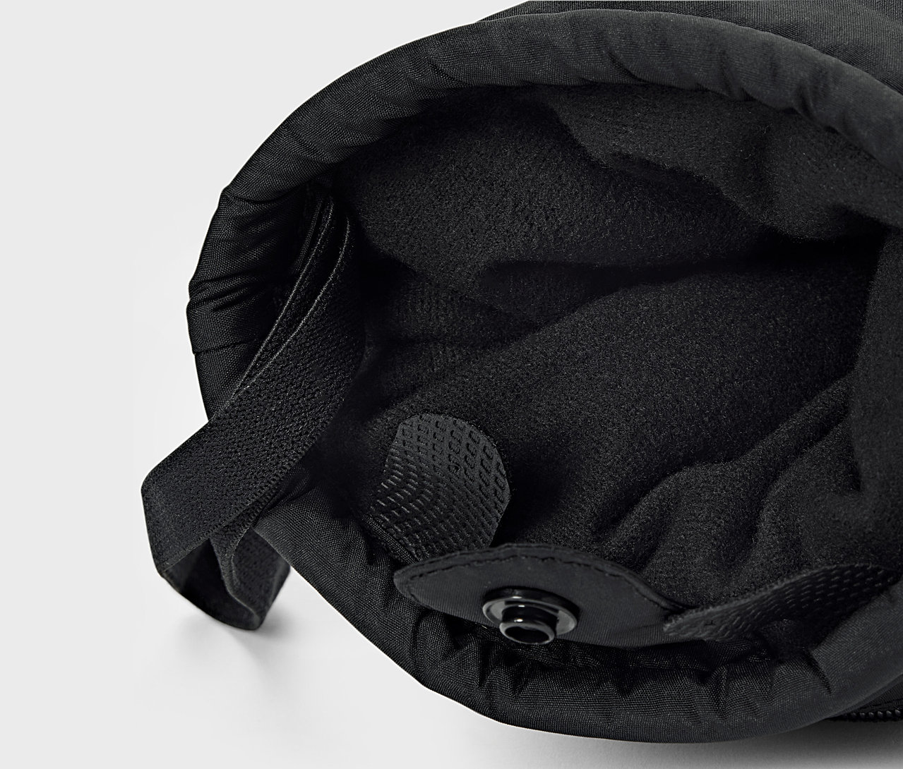 Gros plan d'un tissu noir avec doublure intérieure et cordon de serrage.