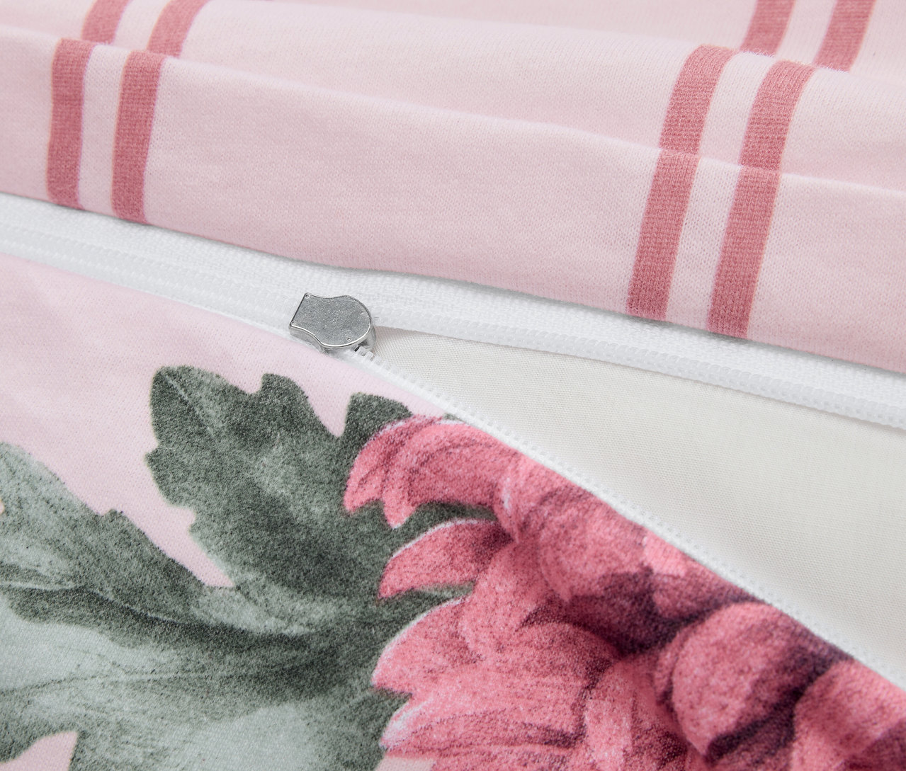 Détail de linge de lit en jersey d'hiver de taille standard avec motif floral, rayures et fermeture éclair argentée.