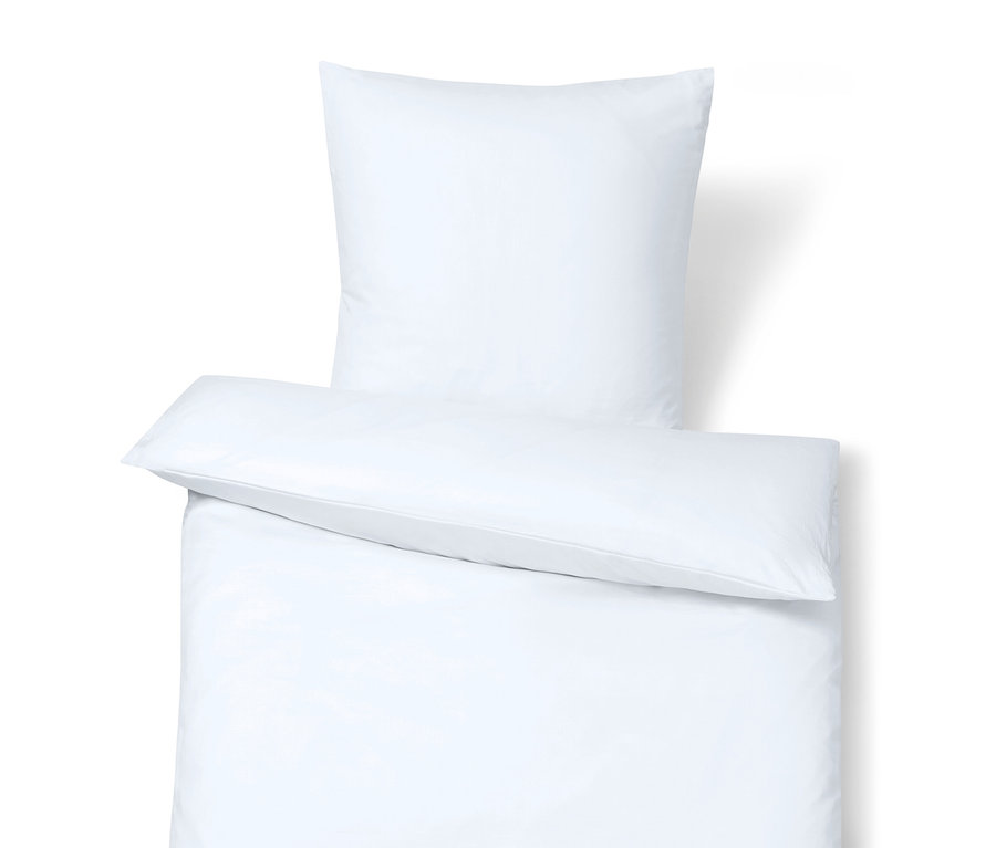 Gros plan sur une parure de lit blanche avec un oreiller sur le dessus.