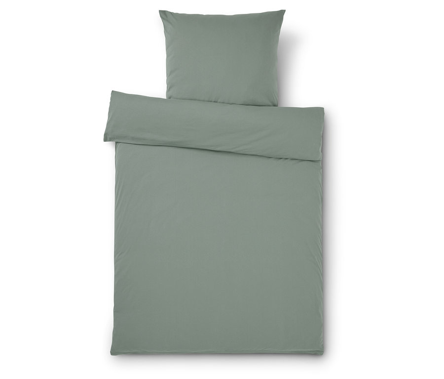 Une parure de lit vert clair comprenant une housse de coussin et une housse de couette sur un fond blanc.