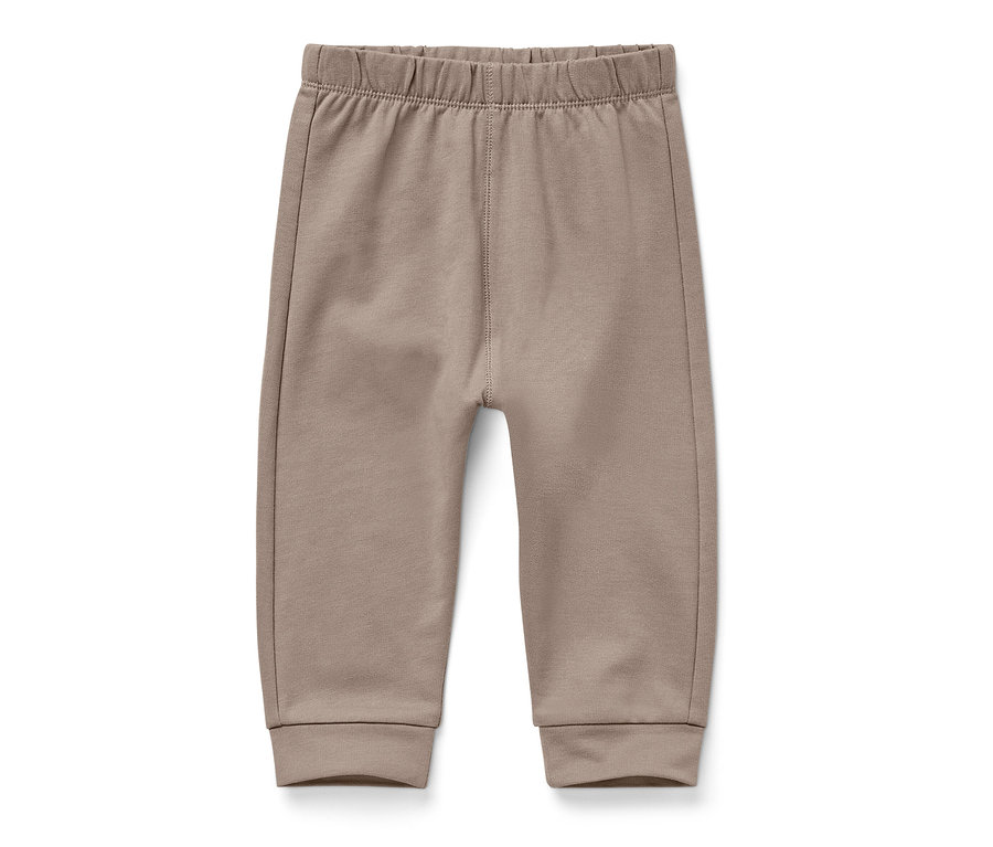 Un pantalon pour bébé marron clair sur un fond blanc.