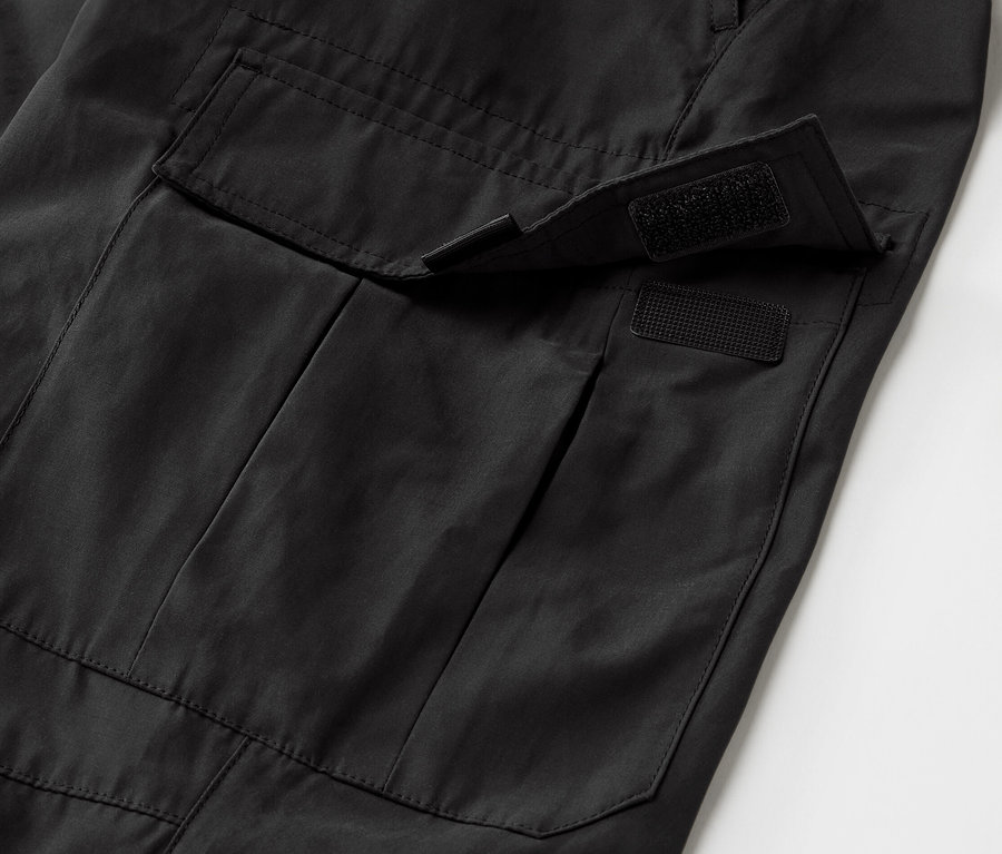 Gros plan d'un pantalon d'extérieur noir avec une poche dotée d'une protection anti-moustiques.