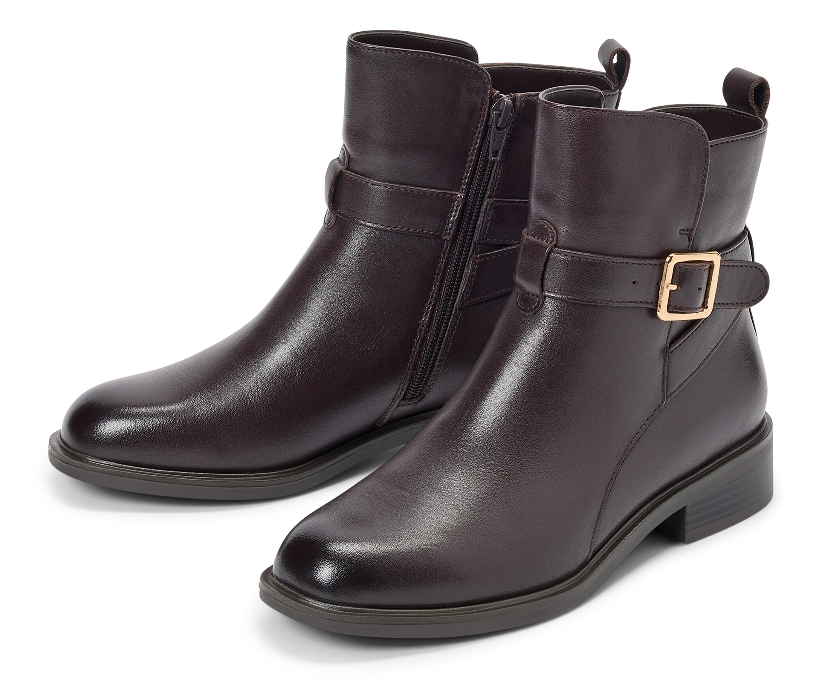 Deux bottines marron avec boucle et fermeture éclair posées sur un fond blanc.