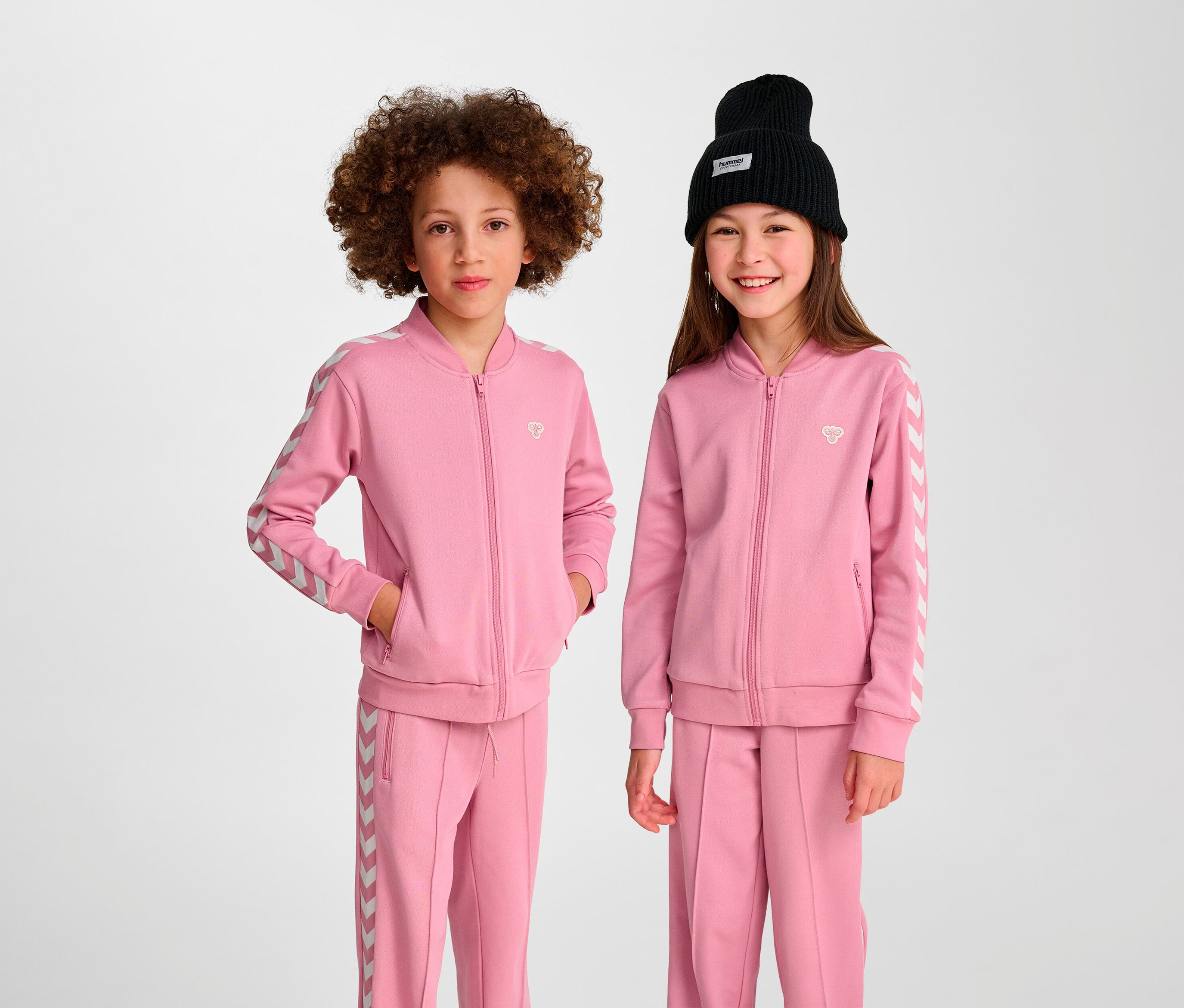 Deux enfants posent en veste rose Hummel HMLJR Archive Reg Poly.