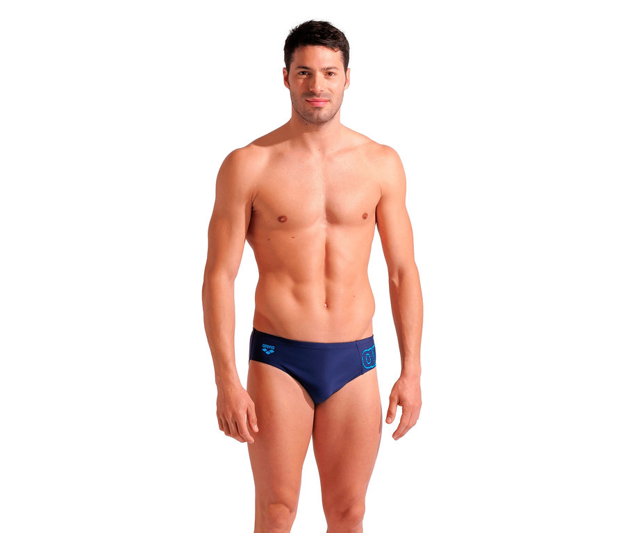 Un homme pose en maillot de bain slip bleu marine Scratchy de arena.