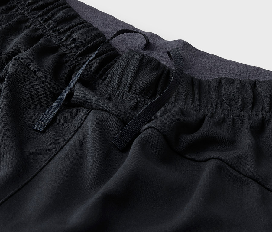 Gros plan sur un pantalon de survêtement noir avec cordon de serrage à la taille.