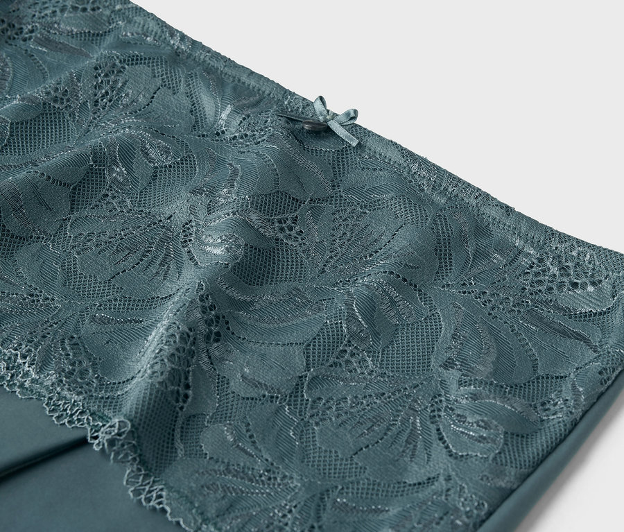 Gros plan sur de la dentelle bleu-vert avec un nœud sur le dessus.