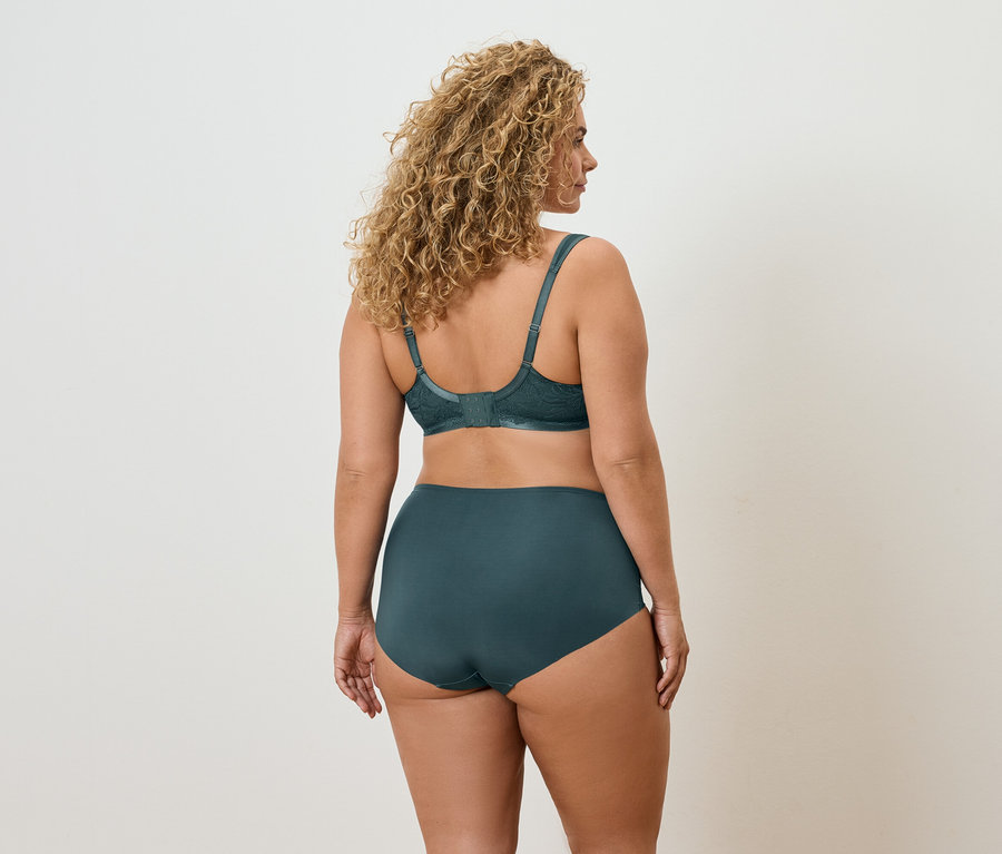 Vue arrière d'une femme aux cheveux bouclés portant un soutien-gorge et une culotte verts.