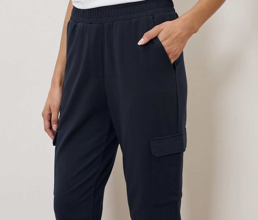 Femme portant un pantalon cargo bleu marine avec une taille élastique et une poche.