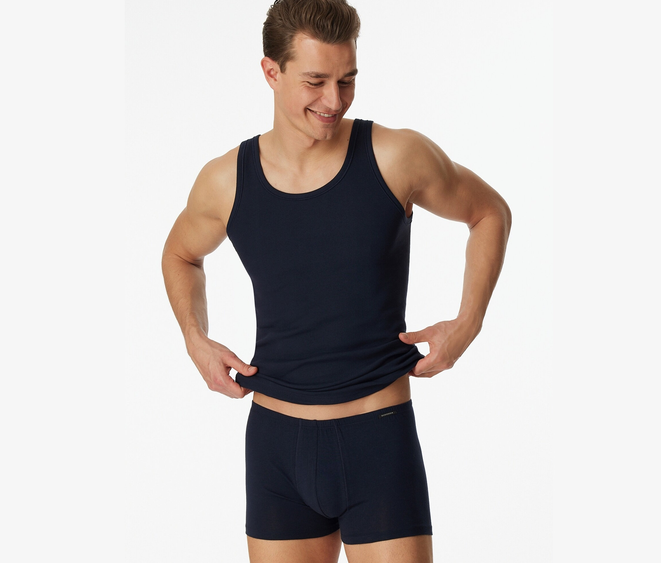 Homme tenant 2 Maillots de corps SCHIESSER en maille côtelée fine, bleu.