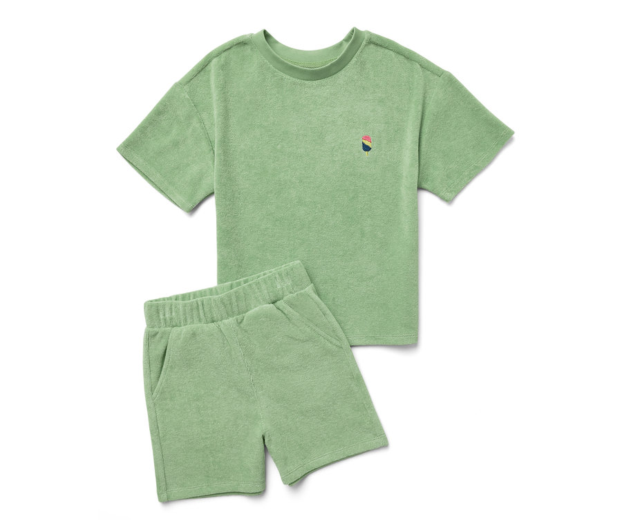 Un ensemble éponge pour enfants vert, composé d'un t-shirt et d'un short, est posé sur un fond blanc.
