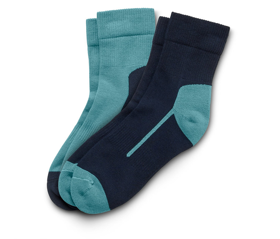 Deux chaussettes posées sur un fond blanc. Une chaussette est bleu-vert, l'autre bleu marine avec des touches de bleu-vert.