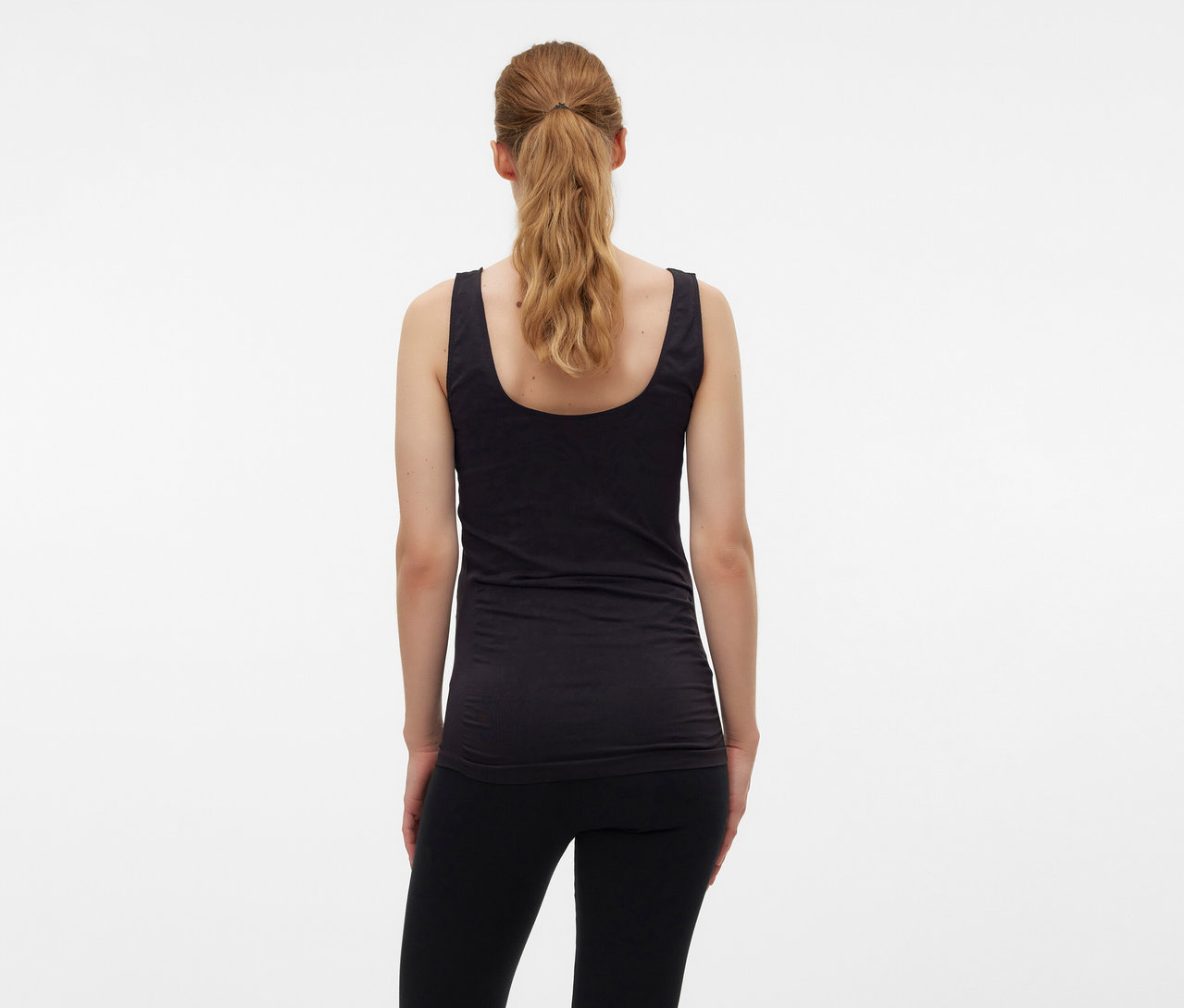 Vue arrière d'une femme blonde aux cheveux attachés en queue de cheval portant un débardeur noir MAMALICIOUS «
MLHEAL
» taille unique.