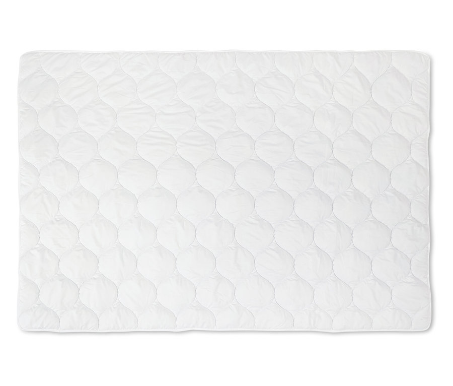 Une couette blanche lavable à haute température, taille standard, est posée à plat sur une surface blanche.