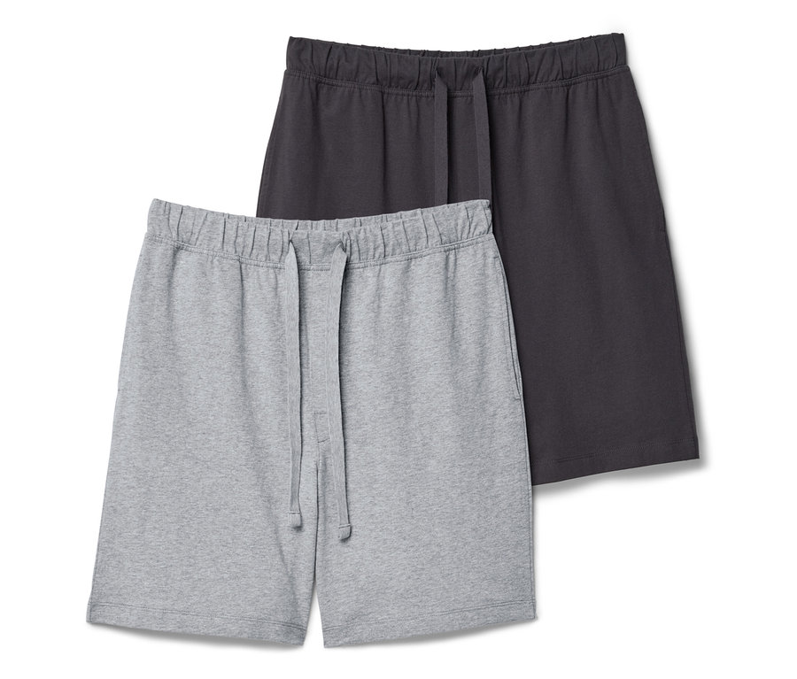 Deux shorts de survêtement, un gris clair et un gris foncé, sont posés l'un sur l'autre.