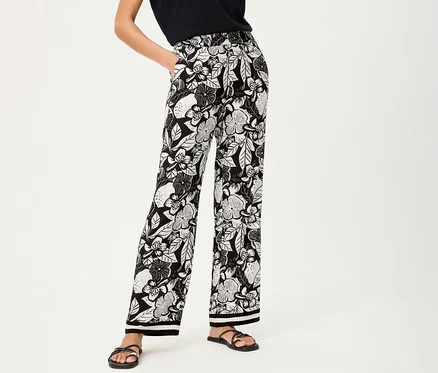 Femme portant un pantalon large Olsen à motif floral et des sandales noires.