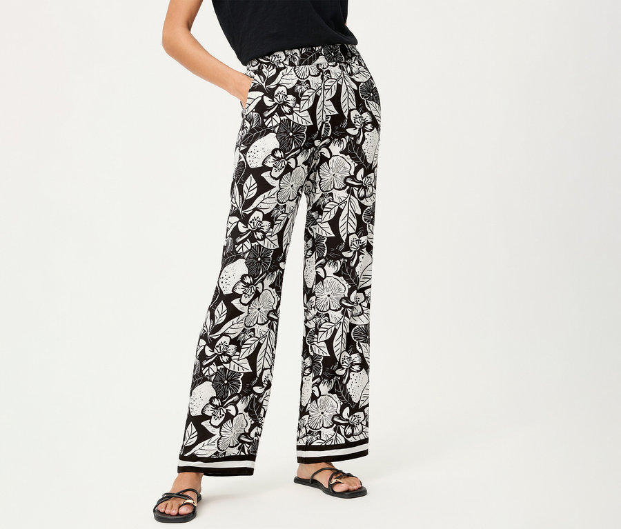 Femme portant un pantalon large Olsen à motif floral et des sandales noires.