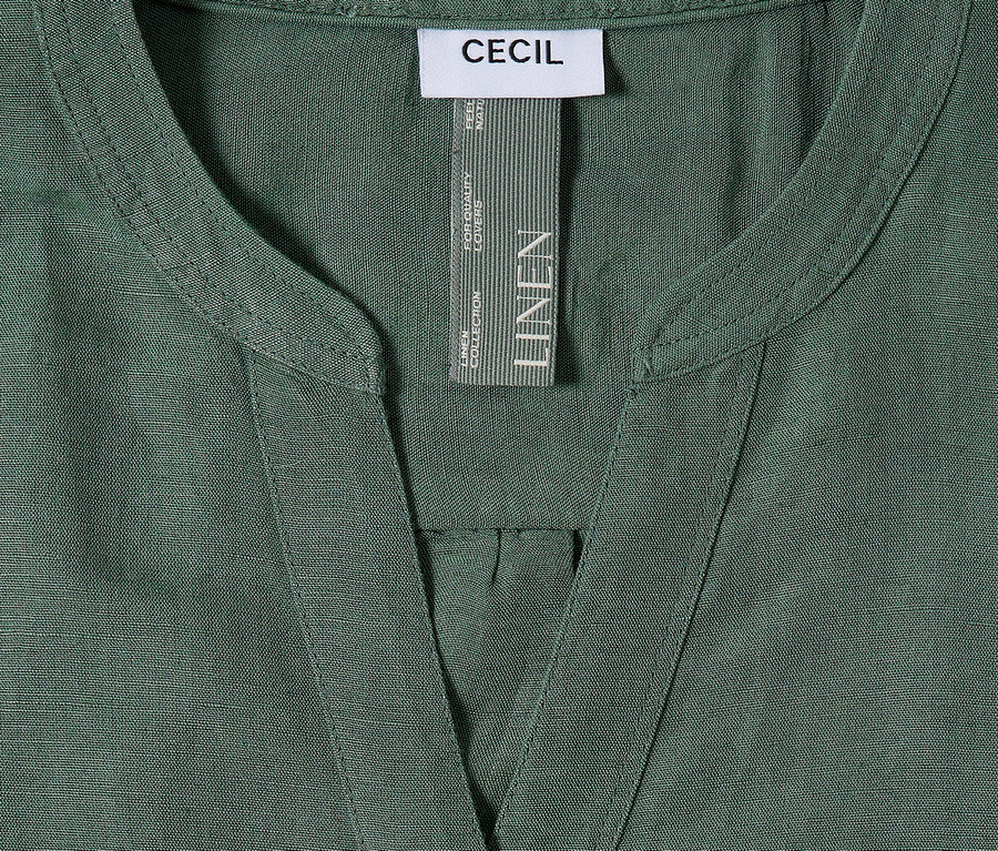 Gros plan d'une chemise en lin verte Cecil avec un col en V et une étiquette.
