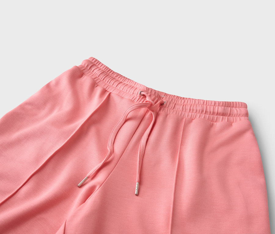 Gros plan d'un pantalon corail avec cordon de serrage.