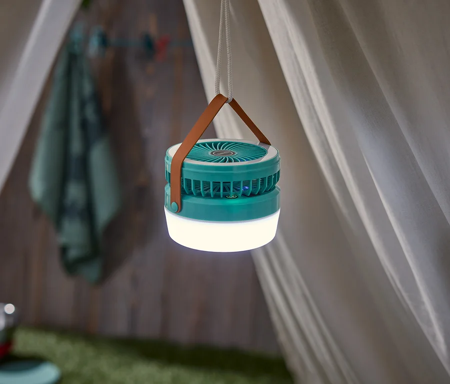 Une lanterne turquoise est suspendue dans une tente avec une sangle marron et une corde blanche.