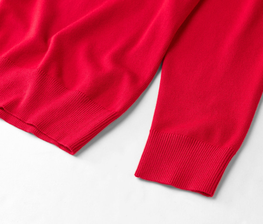 Vue détaillée d'un pull rouge sur fond blanc.