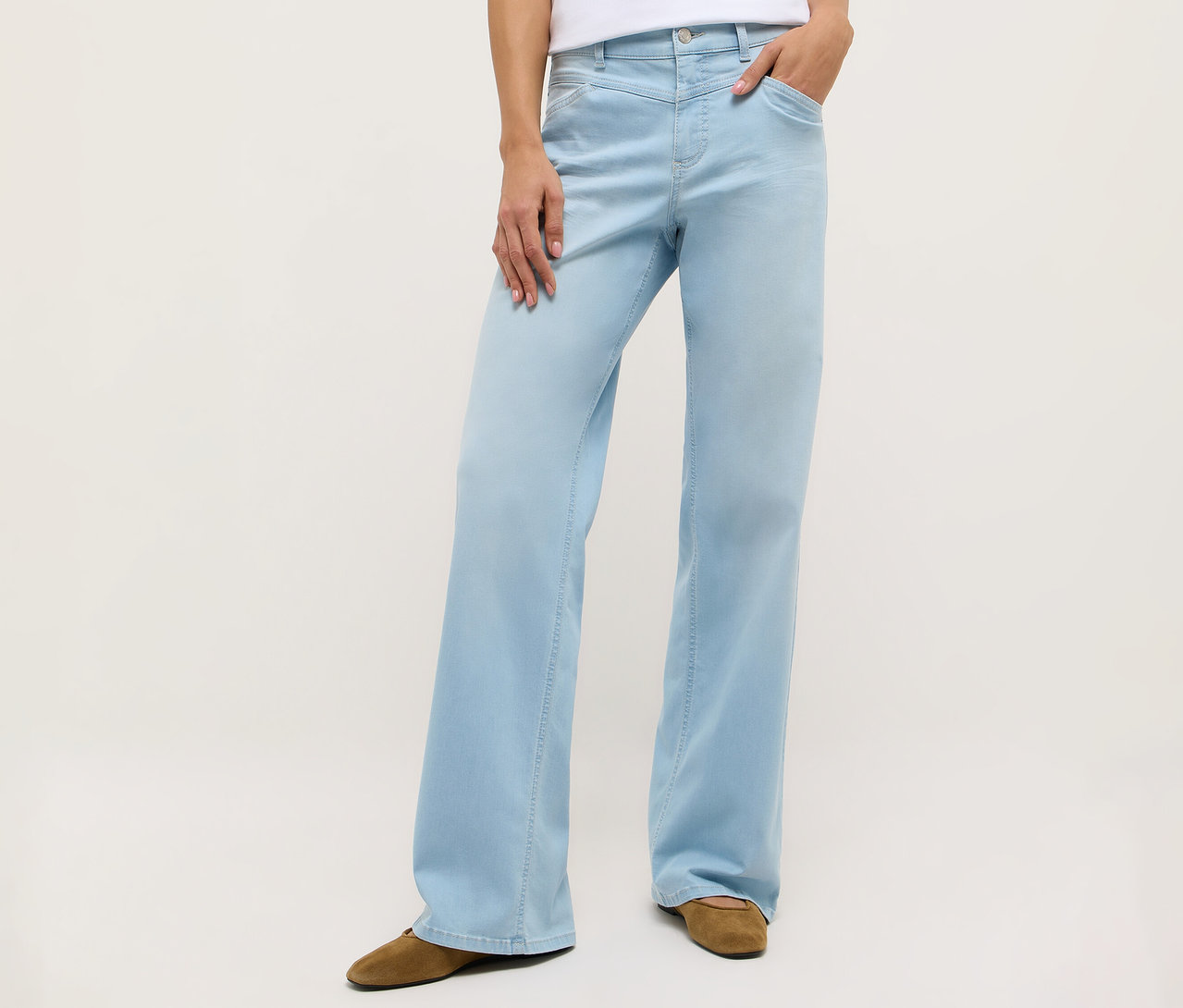 Personne portant un jean Angels Denim «
Liz Modern
» à jambes larges bleu clair et des chaussures marron.